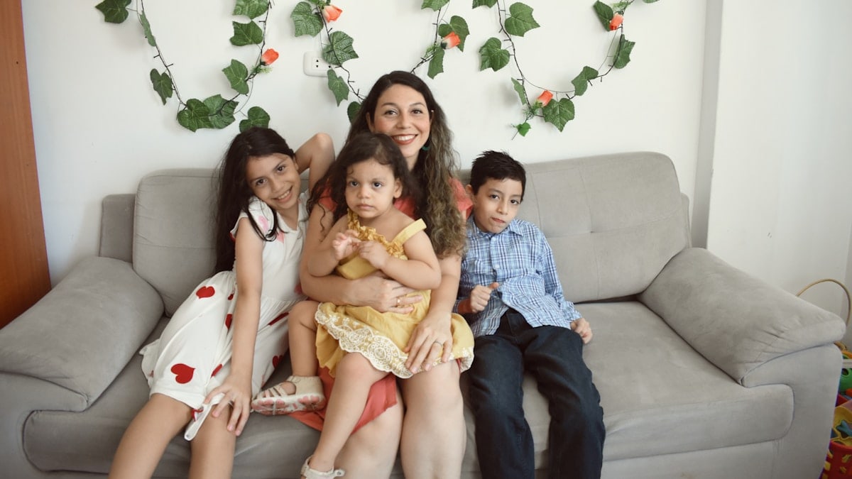 a group of people sitting on a couch posing for the camera